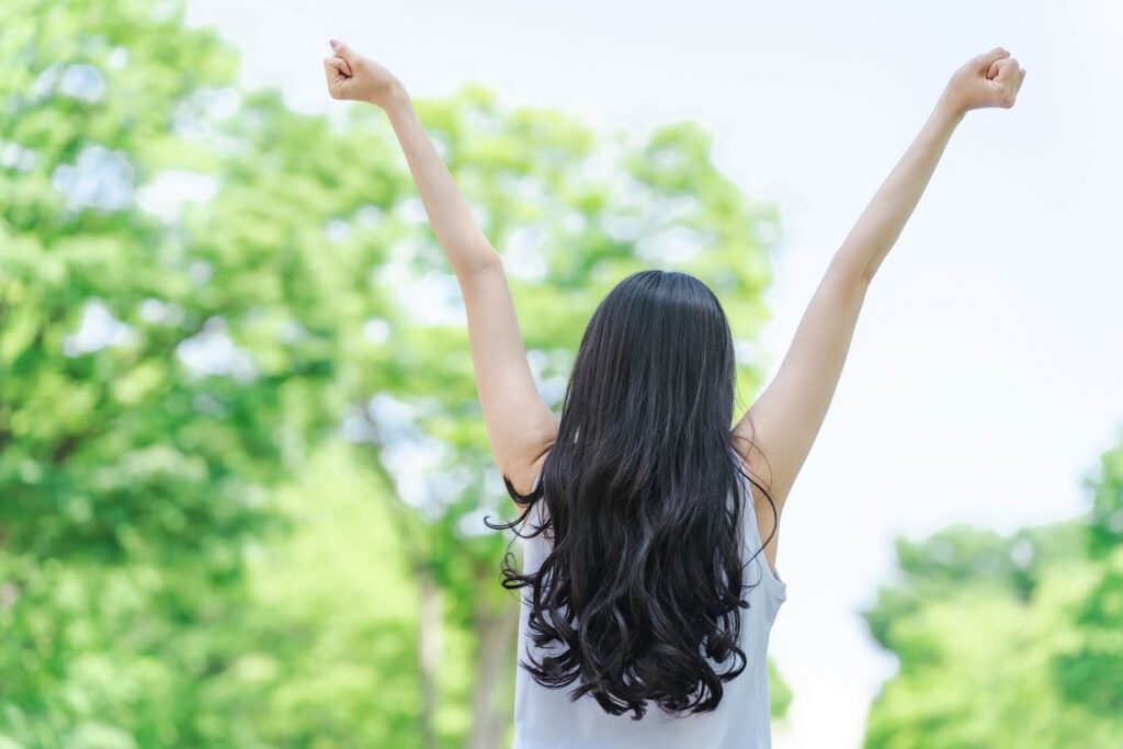 女性が万歳をしている様子